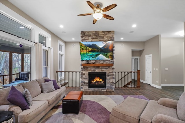 living room with a stone fireplace, ceiling fan, and dark hardwood / wood-style floors