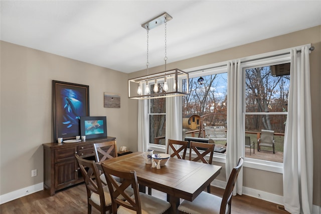 dining space with dark hardwood / wood-style floors and a chandelier