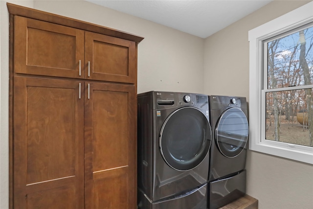 laundry area featuring washing machine and dryer and cabinets