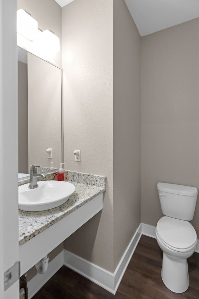 bathroom with hardwood / wood-style floors, toilet, and sink