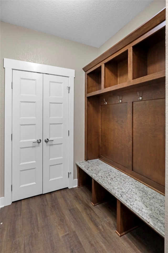 mudroom with a textured ceiling and dark wood-type flooring