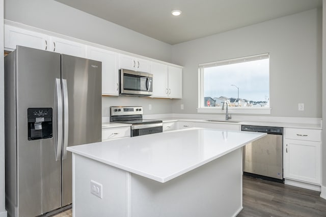 kitchen featuring sink, a center island, dark wood-type flooring, white cabinets, and appliances with stainless steel finishes