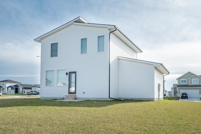 rear view of property featuring a lawn