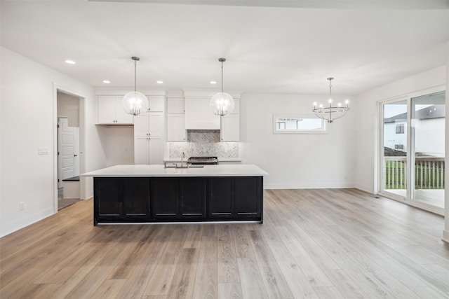 kitchen with white cabinetry, a center island with sink, and light hardwood / wood-style floors