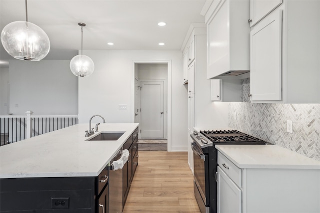 kitchen with appliances with stainless steel finishes, white cabinetry, pendant lighting, and sink