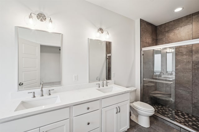 bathroom featuring tile patterned flooring, a shower with door, vanity, and toilet