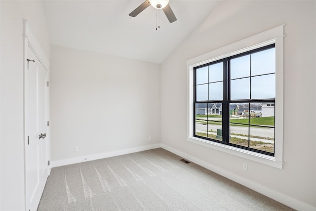 unfurnished bedroom featuring multiple windows, ceiling fan, light carpet, and vaulted ceiling