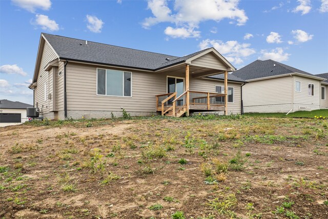 rear view of property with cooling unit and a wooden deck