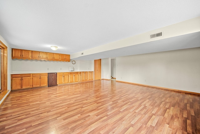 interior space with light wood-type flooring and a textured ceiling