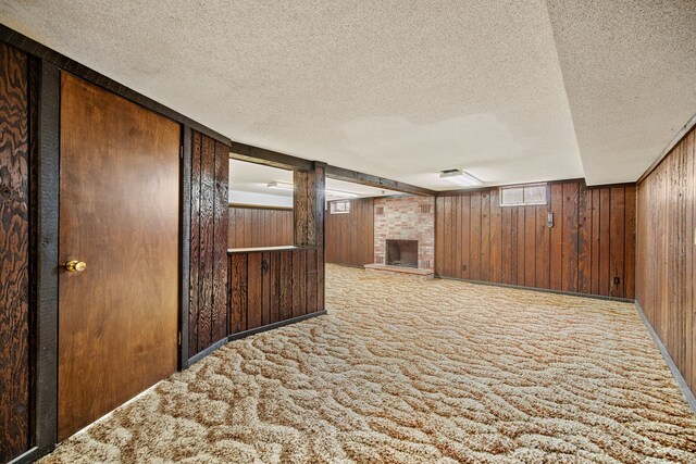 hallway featuring light carpet, a textured ceiling, and wooden walls