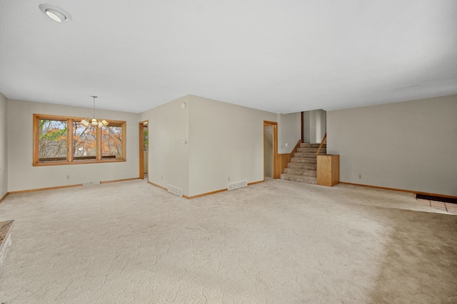 unfurnished living room with carpet flooring and a notable chandelier