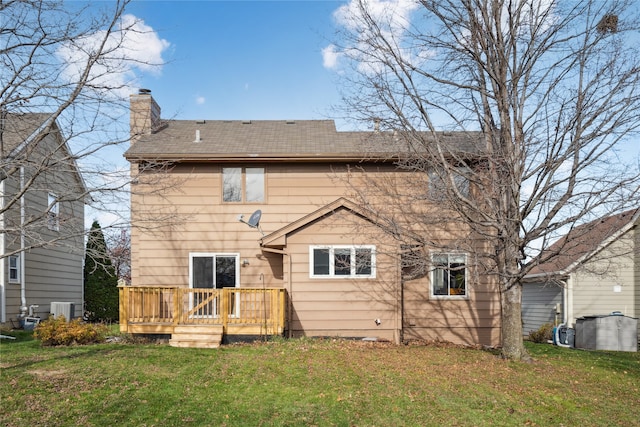 rear view of property with a lawn, central AC unit, and a wooden deck