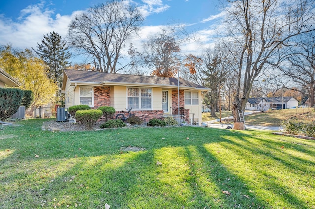 ranch-style home featuring a front lawn and central AC unit