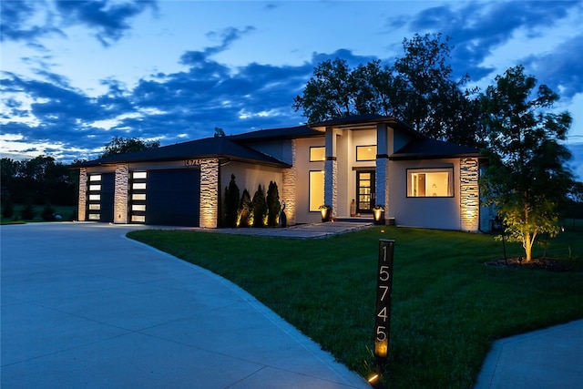 view of front of property featuring a garage and a lawn