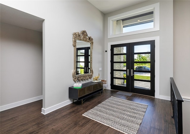 foyer entrance featuring french doors, dark hardwood / wood-style floors, and a high ceiling