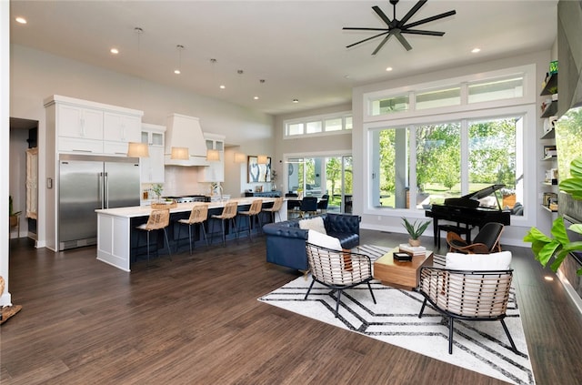 living room featuring ceiling fan, a healthy amount of sunlight, and dark hardwood / wood-style flooring