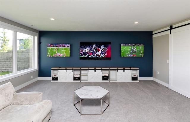 living room featuring a barn door and carpet floors