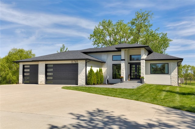 prairie-style home featuring french doors, a front lawn, and a garage