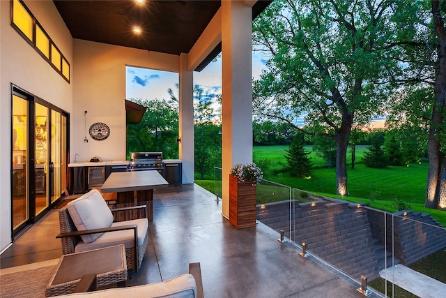 patio terrace at dusk with exterior kitchen and grilling area