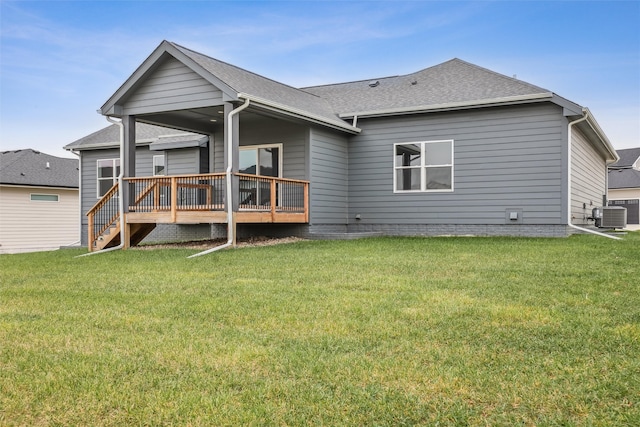 rear view of property with a lawn, central air condition unit, and a wooden deck