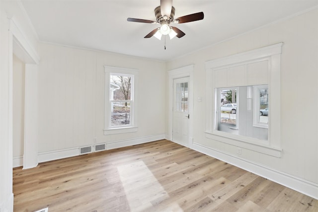 spare room with ceiling fan, crown molding, and light wood-type flooring