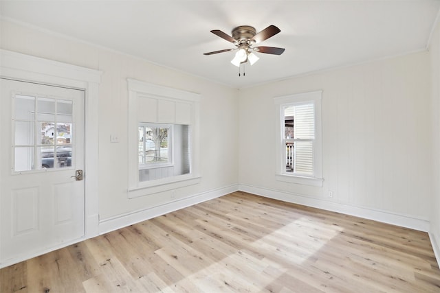 foyer entrance featuring light wood-type flooring, ceiling fan, ornamental molding, and a healthy amount of sunlight