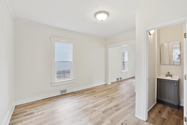 entryway with light hardwood / wood-style floors, sink, and ornamental molding