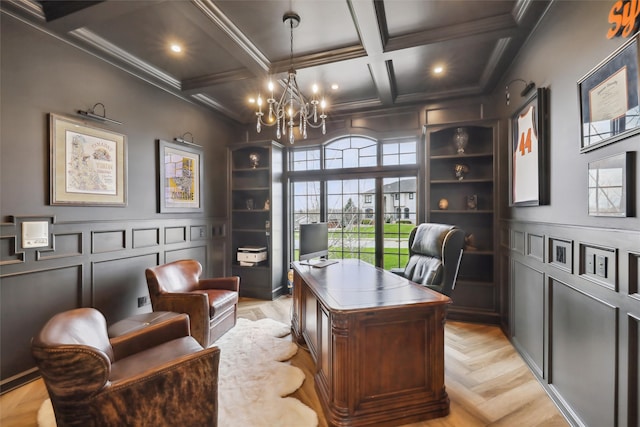 office space featuring built in shelves, coffered ceiling, beamed ceiling, a notable chandelier, and ornamental molding