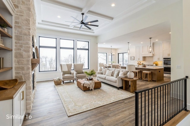 living room featuring ceiling fan, beamed ceiling, coffered ceiling, and hardwood / wood-style flooring