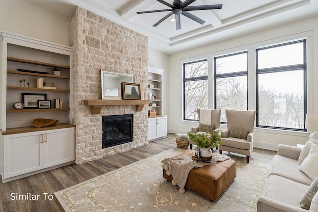 living room featuring hardwood / wood-style floors, a fireplace, beamed ceiling, and coffered ceiling