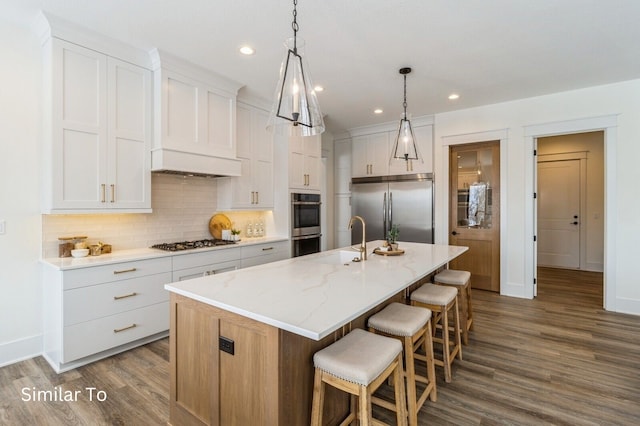 kitchen with a center island with sink, white cabinetry, and appliances with stainless steel finishes