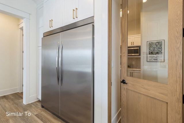 kitchen with white cabinetry, light hardwood / wood-style flooring, and appliances with stainless steel finishes