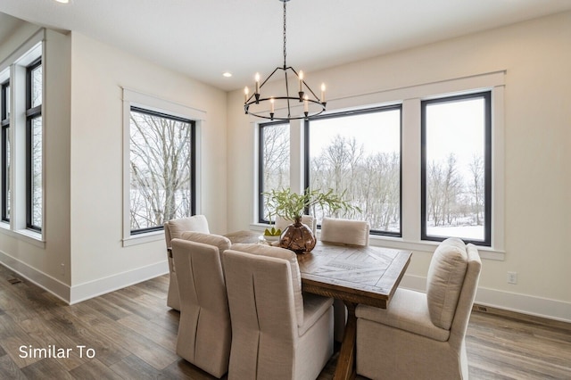 dining area with dark hardwood / wood-style flooring and an inviting chandelier