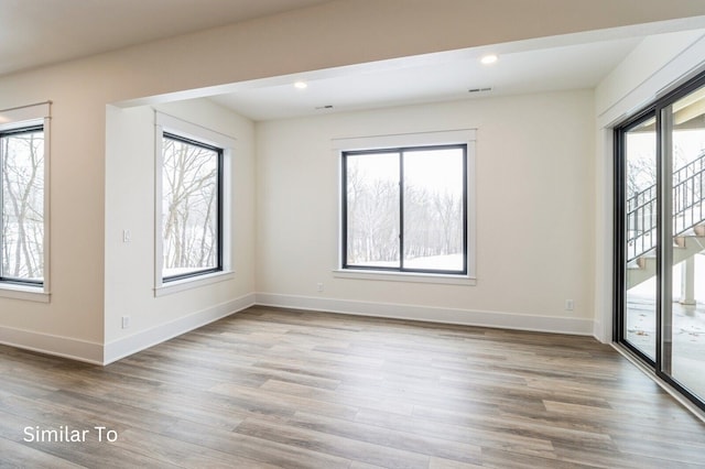 empty room featuring light hardwood / wood-style floors and plenty of natural light