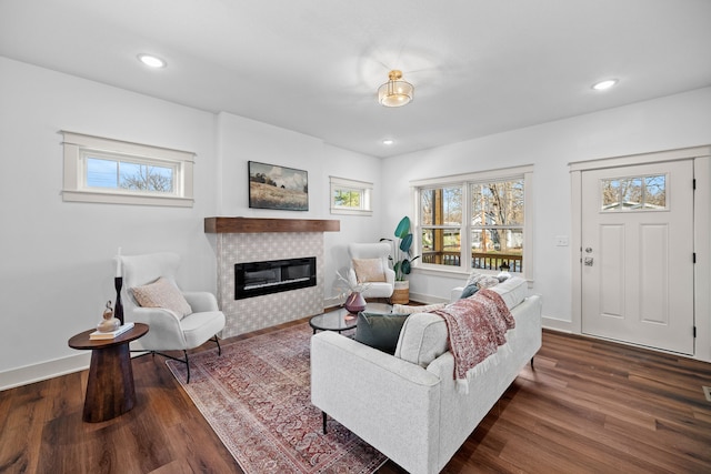 living room with dark hardwood / wood-style floors and a tiled fireplace