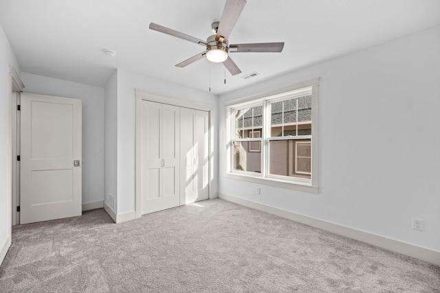 unfurnished bedroom with ceiling fan, light carpet, and a closet