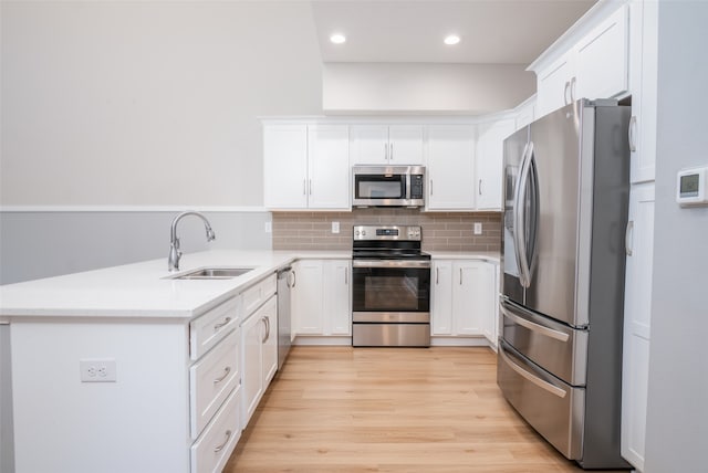 kitchen featuring white cabinets, appliances with stainless steel finishes, tasteful backsplash, and sink