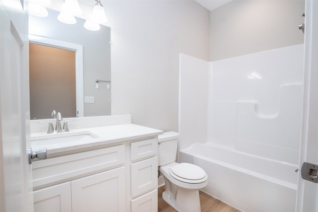 full bathroom with shower / bathing tub combination, hardwood / wood-style floors, vanity, and toilet