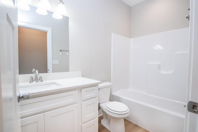 full bath with bathtub / shower combination, wood finished floors, vanity, and toilet