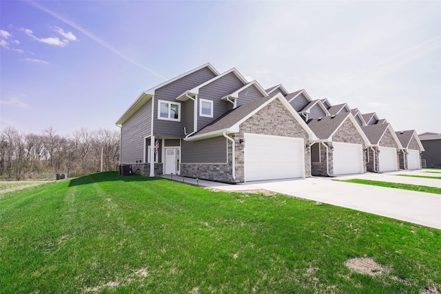 craftsman inspired home featuring central AC unit, driveway, stone siding, a garage, and a front yard