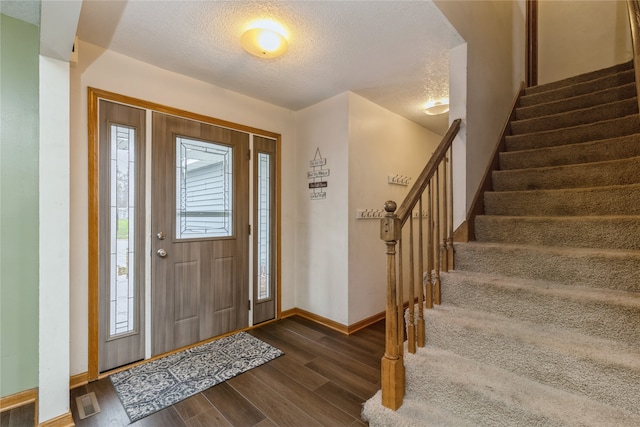 foyer entrance featuring dark hardwood / wood-style flooring and a textured ceiling