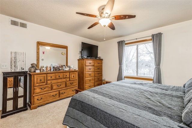 bedroom featuring a textured ceiling, carpet floors, and ceiling fan