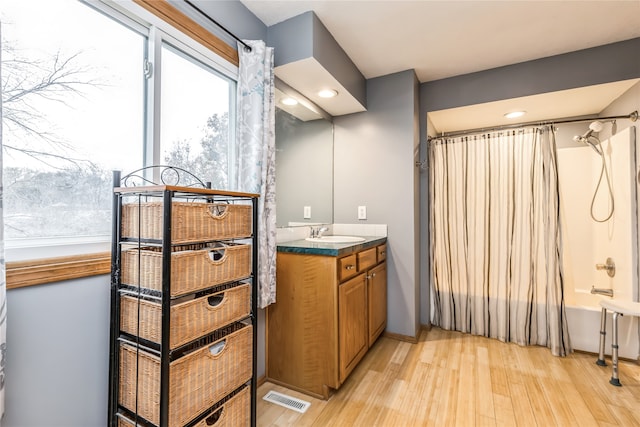 bathroom with shower / bath combo with shower curtain, wood-type flooring, and vanity