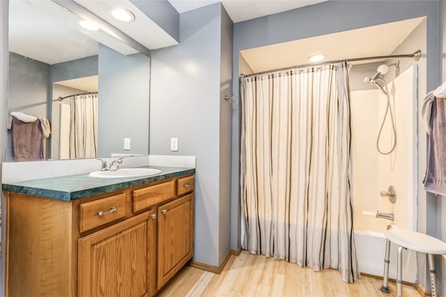 bathroom with hardwood / wood-style floors, vanity, and shower / bathtub combination with curtain