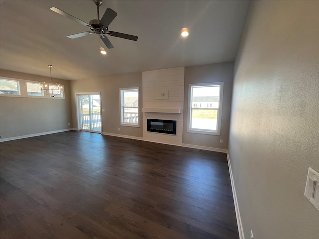 unfurnished living room with a fireplace, dark hardwood / wood-style floors, and ceiling fan with notable chandelier