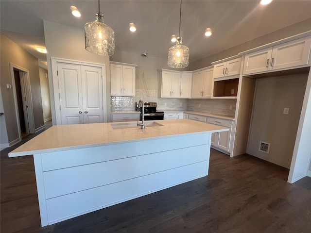 kitchen with tasteful backsplash, pendant lighting, sink, an island with sink, and white cabinets