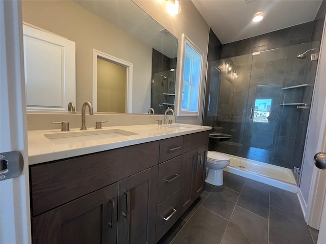 bathroom with a shower with shower door, toilet, vanity, and tile patterned flooring