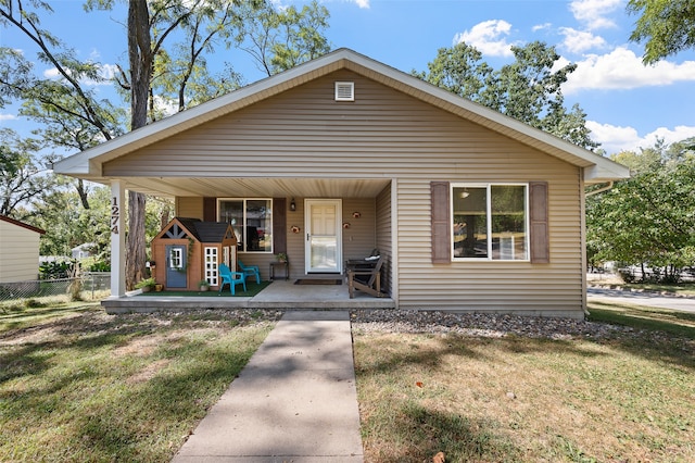 bungalow-style house with a front lawn and covered porch