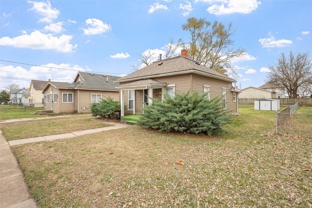 view of front facade featuring a shed and a front lawn