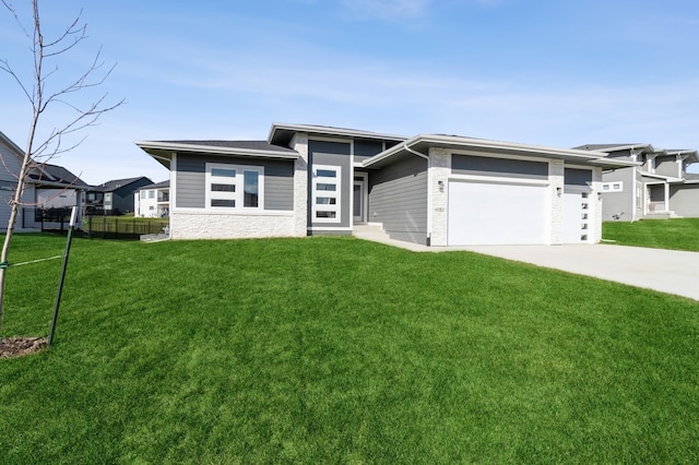 prairie-style home featuring a garage and a front yard